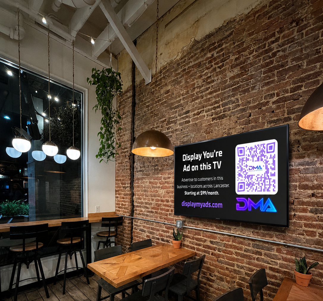 A Display My Ads screen on a brick wall inside a local Lancaster cafe